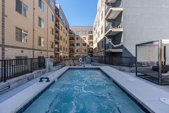 A small pool in a courtyard surrounded by buildings.